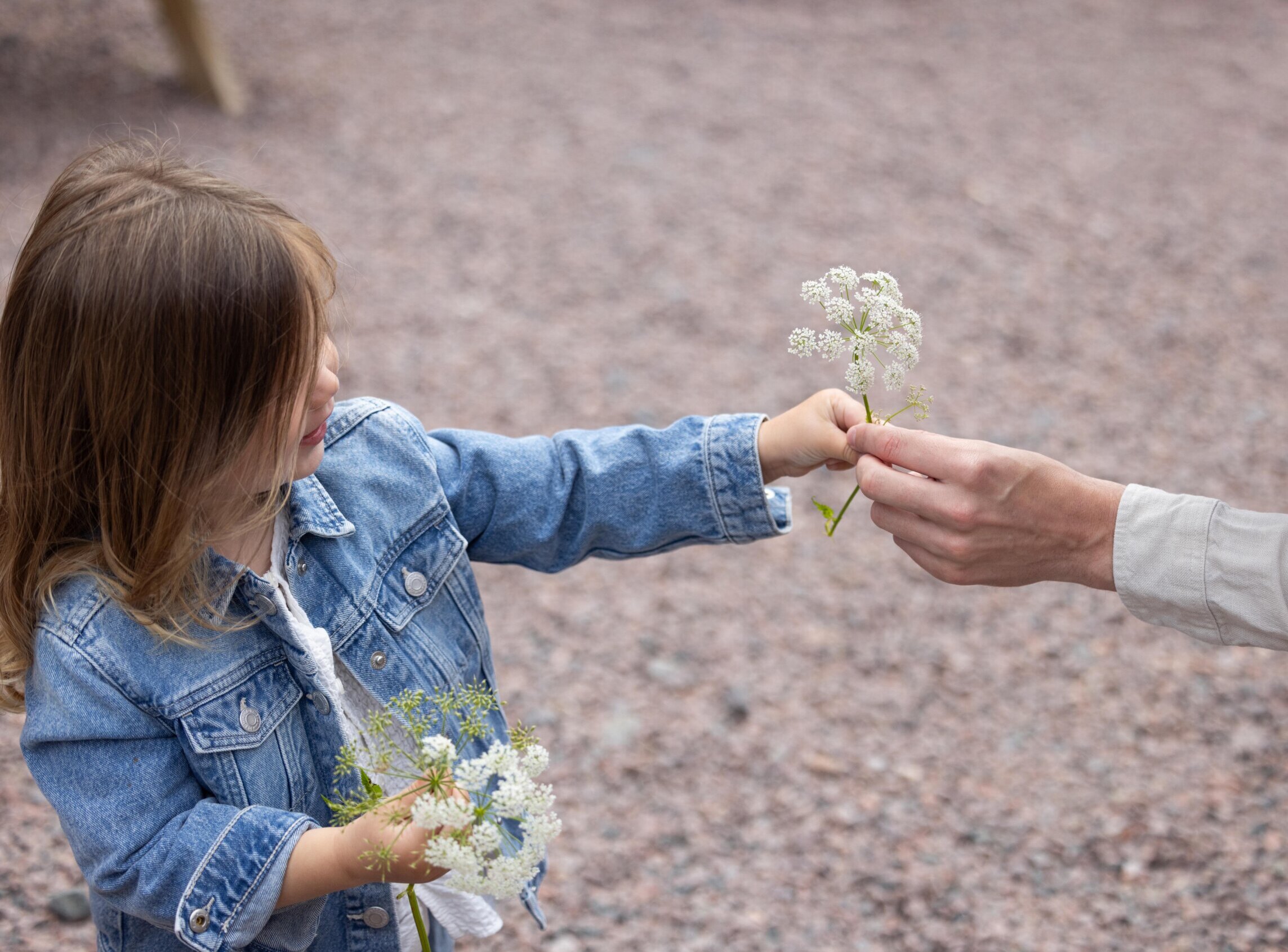 Flicka som håller blommor i handen.