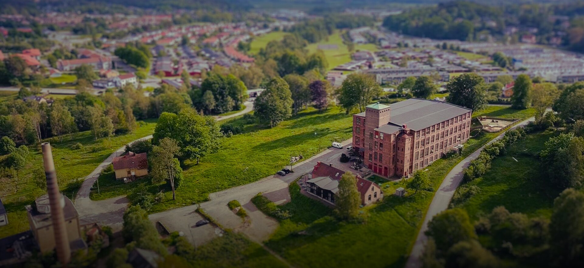Flygfoto över Spinneriet i Lindome. Grönska runt om fastigheten.