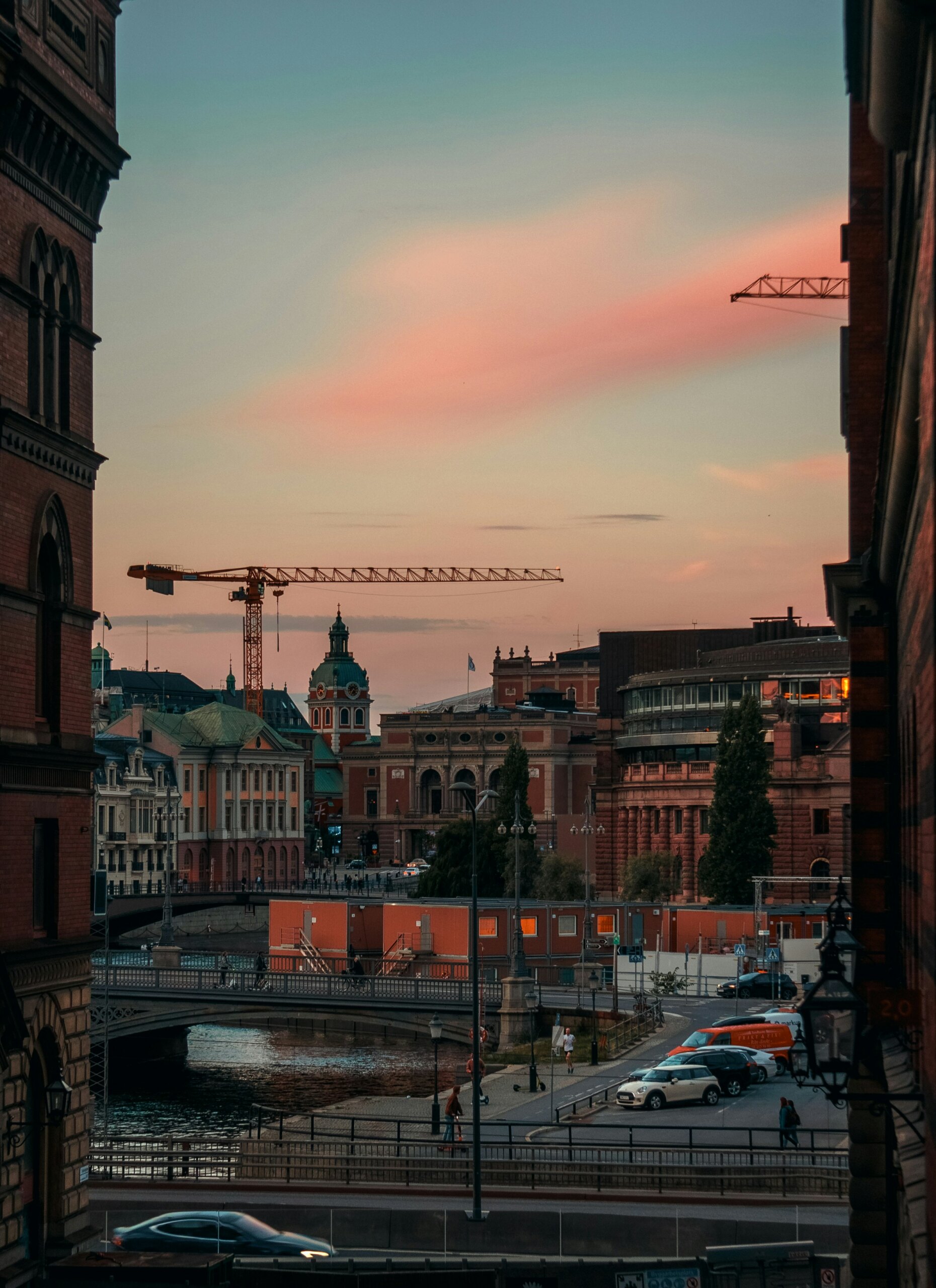 Stadsbild med byggkran som syns över takåsarna.